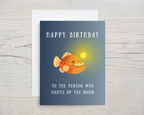Birthday card with a cartoon fish on a blue background, featuring text 'Happy Birthday to the person who lights up the room'.