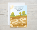 Birthday card with fossil illustration and humorous text on a wooden surface
