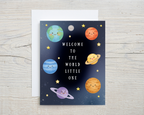 Greeting card with cartoon planets and stars on a wooden surface