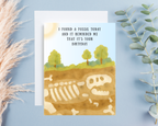Birthday card with fossil illustration and humorous text on a light blue background