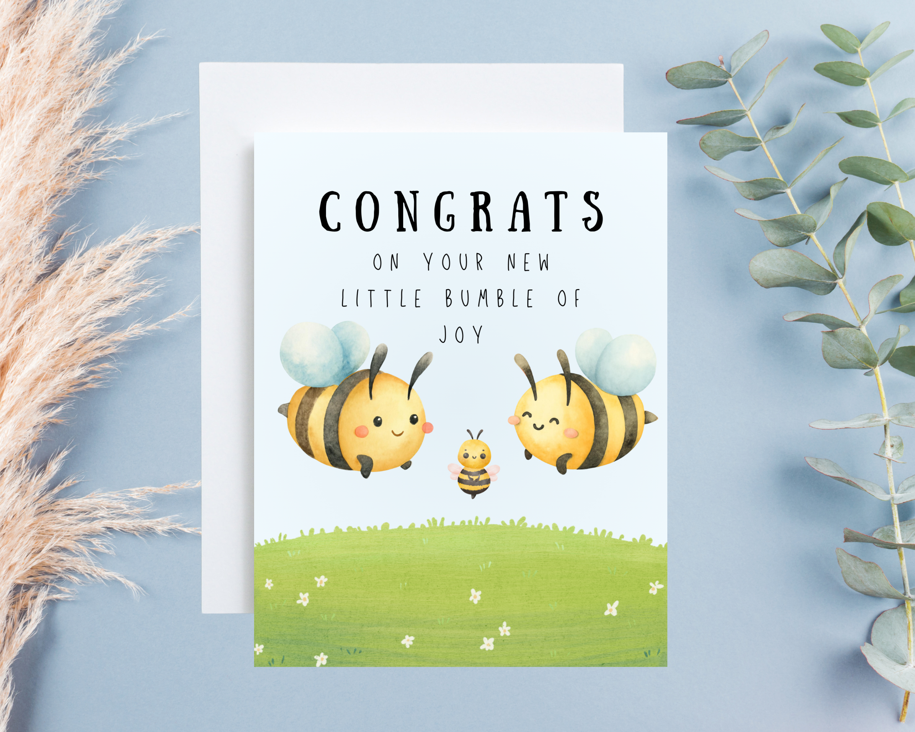 Greeting card with cartoon bees and 'Congrats on your new little bumble of joy' text on a light blue background.