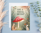 Greeting card with a red mushroom and animals on a blue background