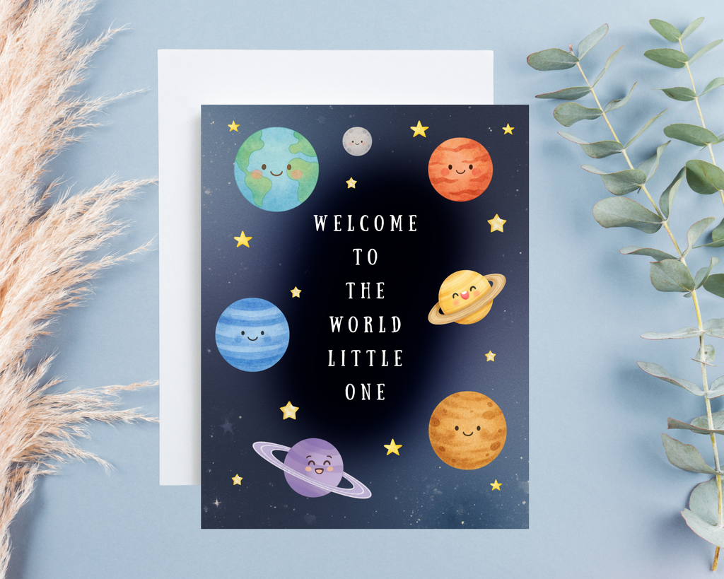 Greeting card with cartoon planets and text 'Welcome to the world little one' on a blue background.