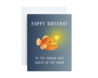 Birthday card with a cartoon angler fish and humorous text "Happy Birthday To The Person Who Lights Up The Room" on a blue background